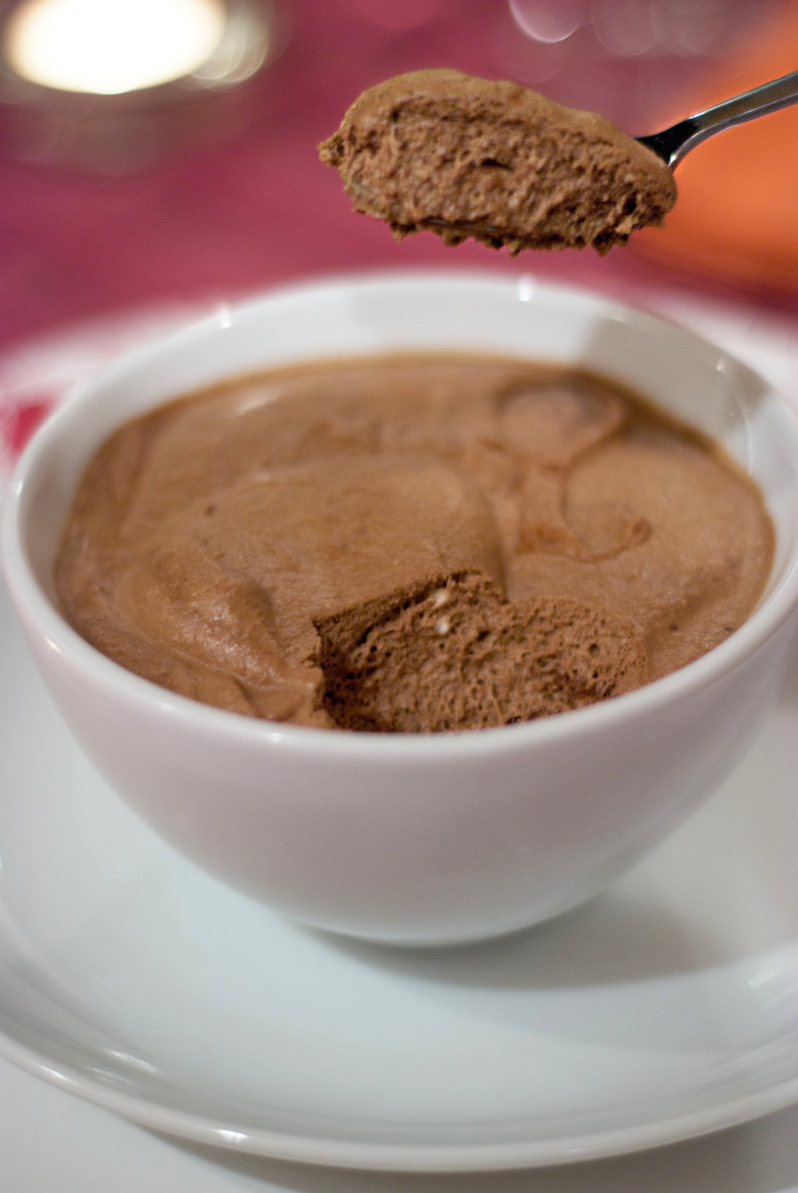 A white cup filled with softly set chocolate mousse